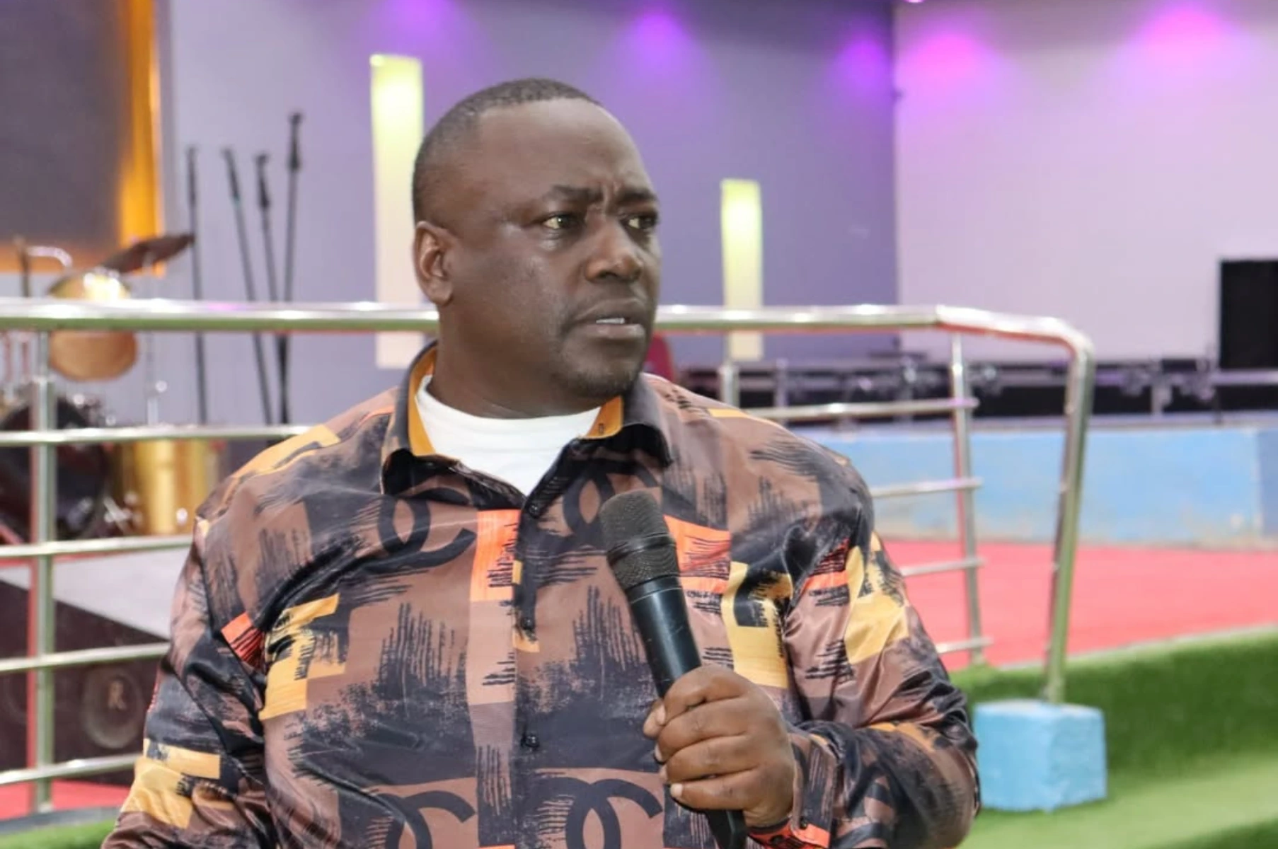 Victor Kanyari speaking into a microphone during a church service