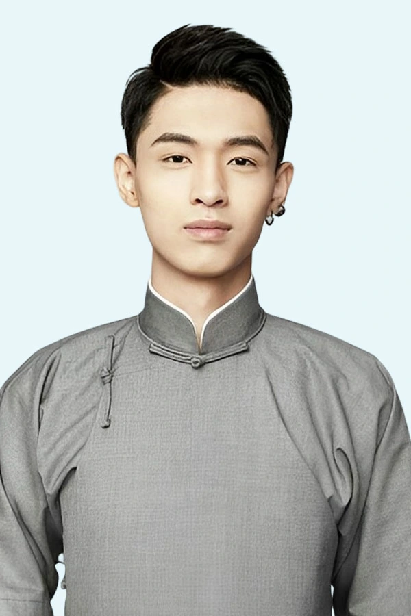 Portrait of a young man in a gray traditional-style shirt against a light background